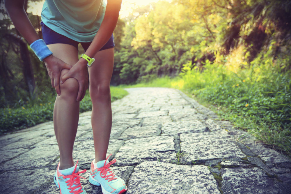 woman runner hold her sports injured knee